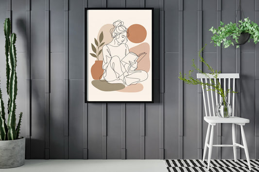 Woman sitting with a book open in her lap, line art print framed in a room with plants
