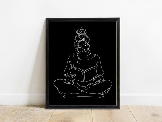 Woman sitting cross-legged reading a book, continuous line art print, white lines on black, in a black frame