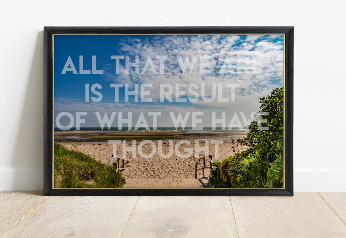 Buddha All that we are is the result of what we have thought quote over a photograph of a beach path on Anglesey, in a black frame
