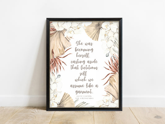 Kate Chopin she was becoming herself quote with white flowers and palm leaves, in a black frame