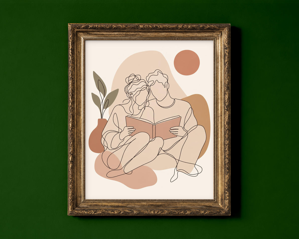 Line art of a couple sitting together reading one book, in blush and terracotta boho colours shown in a gold frame for display only; framed prints are sent in a black frame