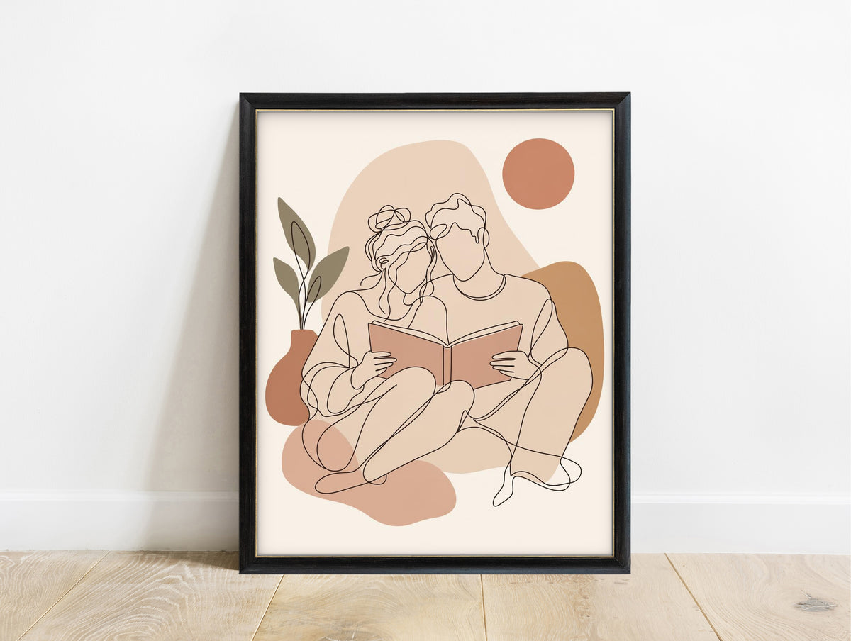 Line art of a couple sitting together reading one book, in blush and terracotta boho colours in a black frame