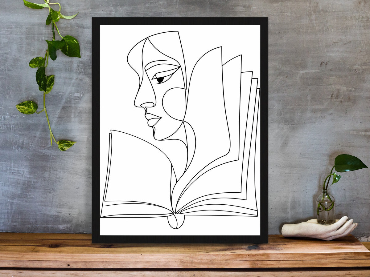 Abstract face in profile flowing into an open book, line art print, black lines on white, framed on a desk