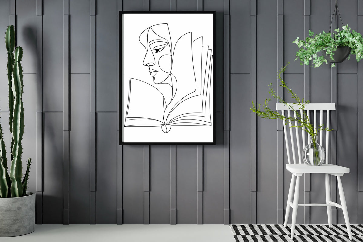 Abstract face in profile flowing into an open book, line art print, black lines on white, framed in a room with plants