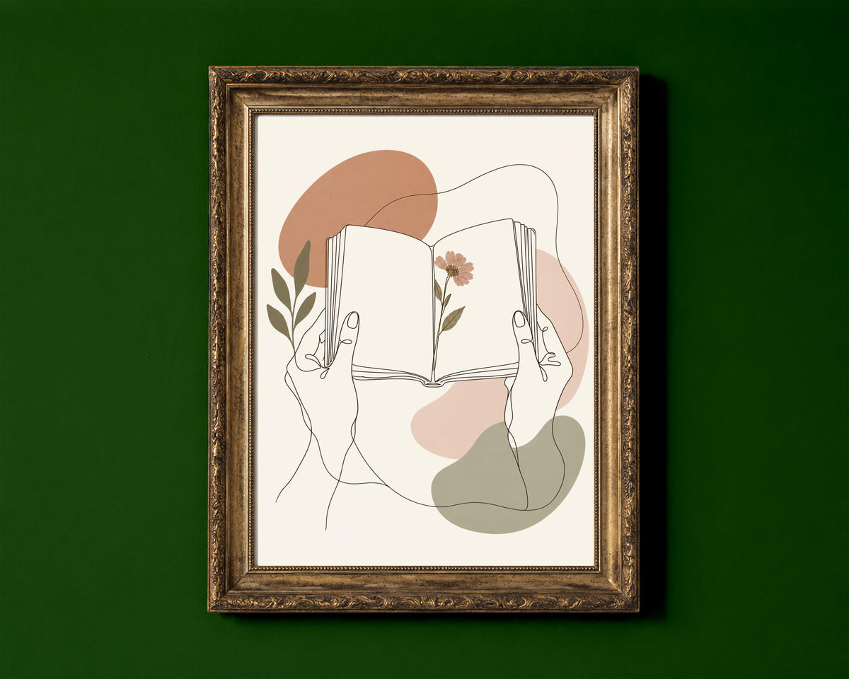 Hands holding an open book with a pressed flower, line art print shown in a gold frame for display only; framed prints are sent in a black frame