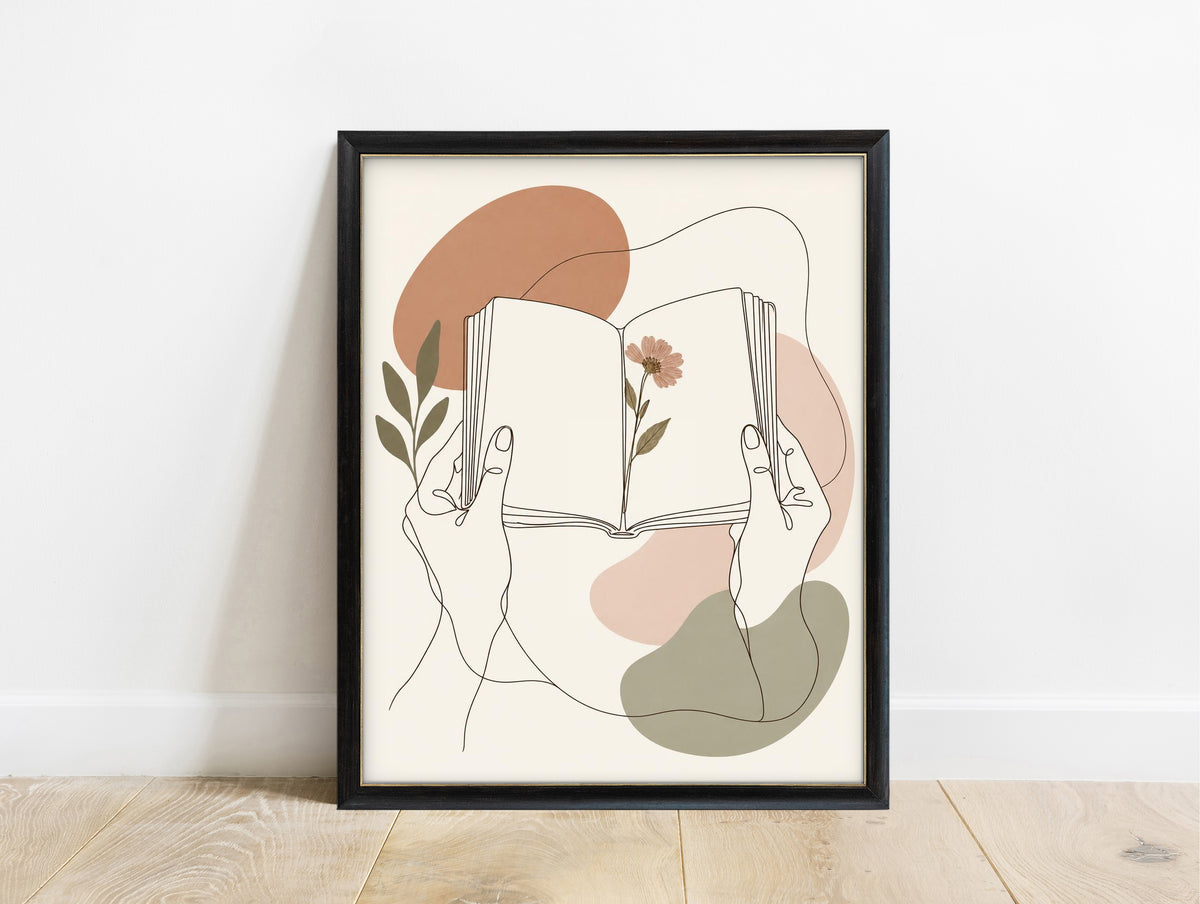 Hands holding an open book with a pressed flower, line art print in a black frame