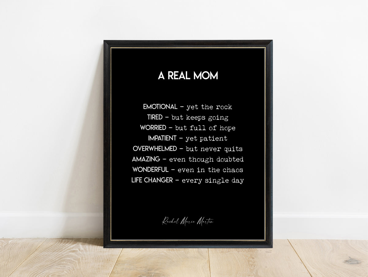 Rachel Marie Martin A Real Mom quote print in a black frame, black background