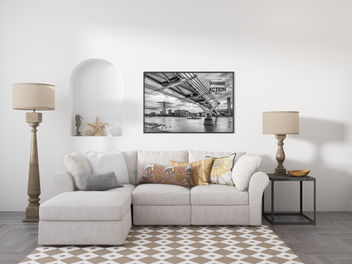 Tony Robbins massive determined action quote over a black and white photograph of the Millennium Bridge, London, shown framed in a living room