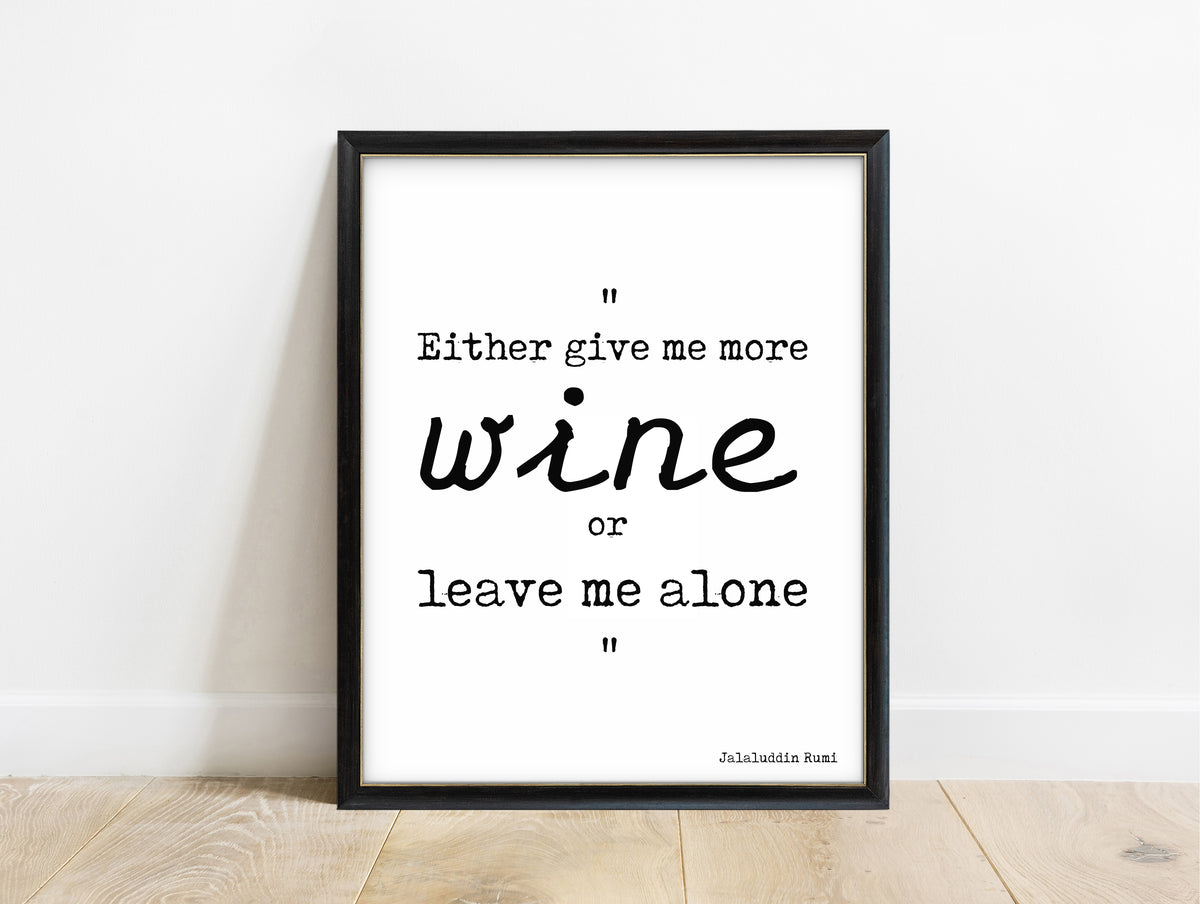 Rumi Either Give Me More Wine quote print in a black frame, white background