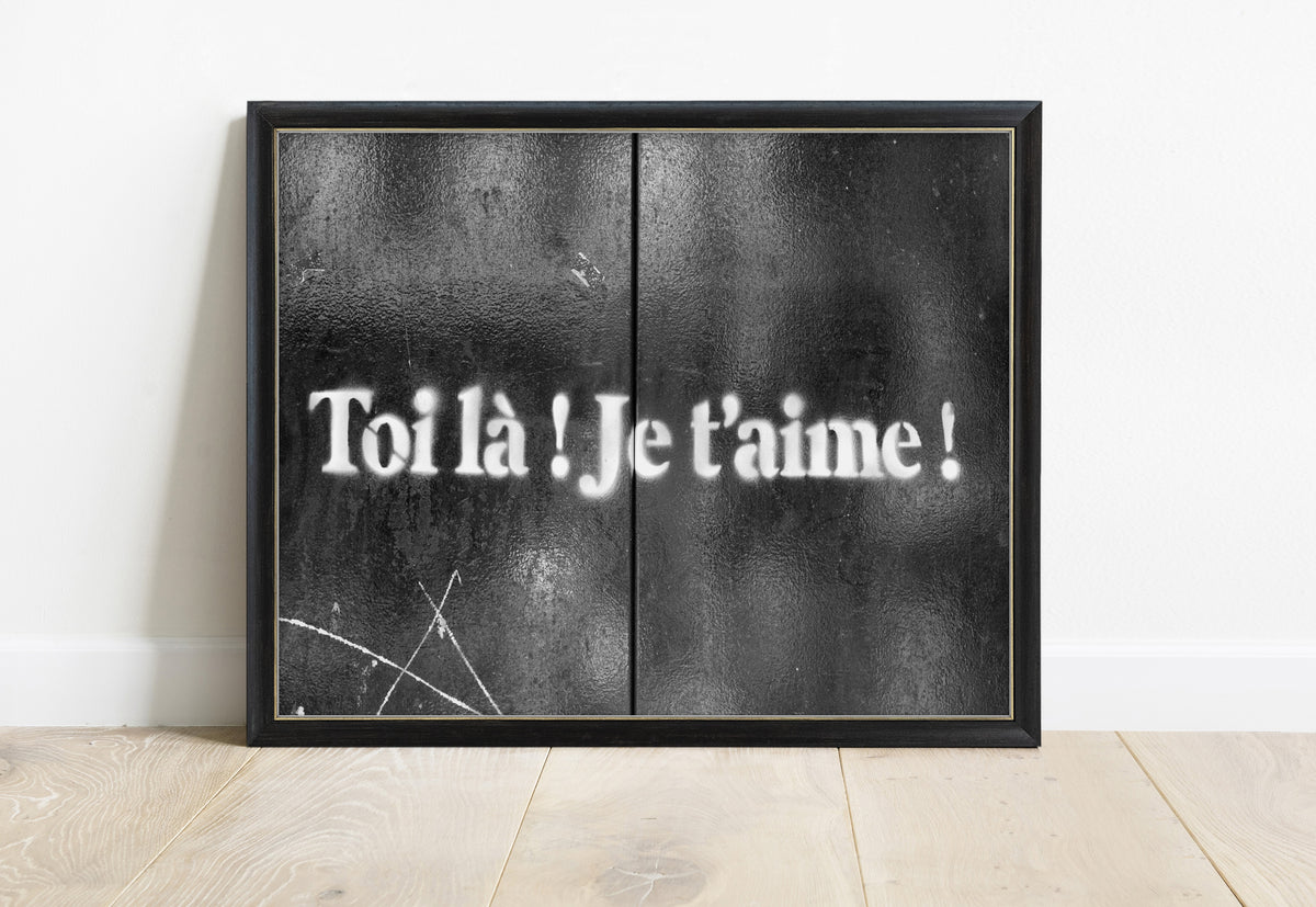 Toi là je t'aime stencilled in white on black doors in Paris, street art photograph, in a black frame