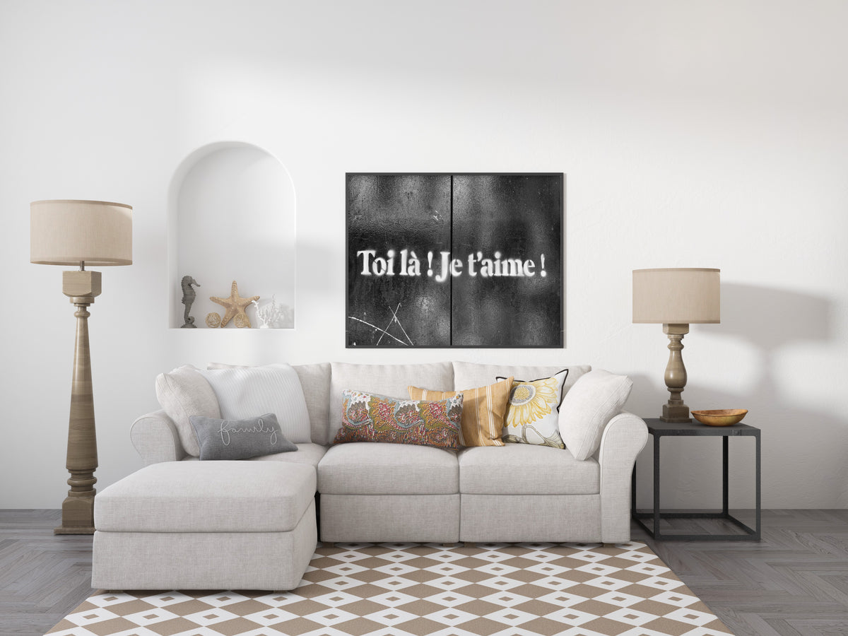Toi là je t'aime stencilled in white on black doors in Paris, street art photograph, shown framed in a living room