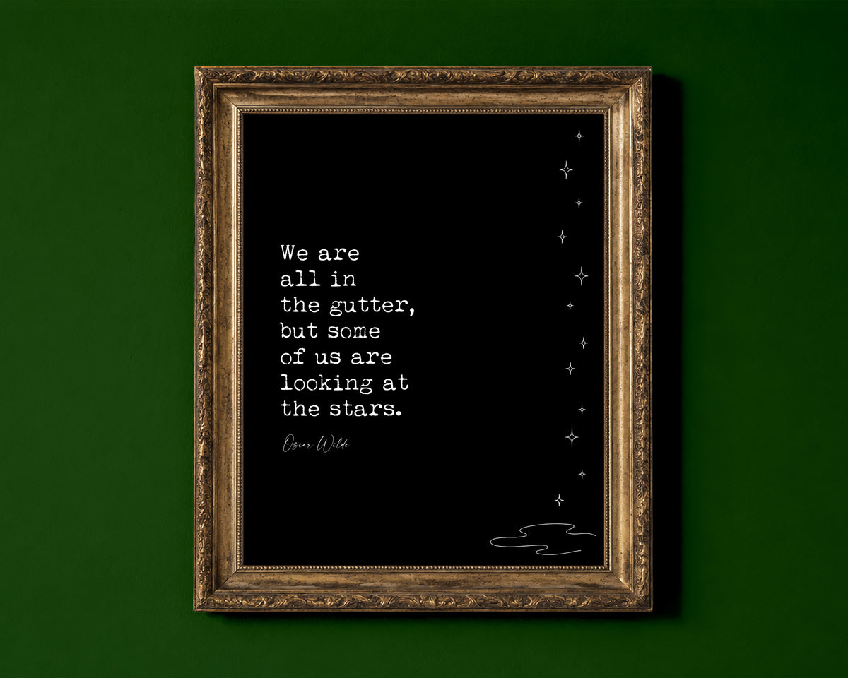 Oscar Wilde We are all in the gutter but some of us are looking at the stars quote print with line art stars, black background, shown in a gold frame for display only; framed prints are sent in a black frame