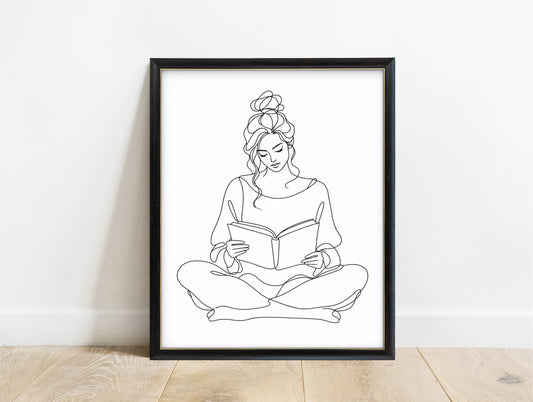 Woman sitting cross-legged reading a book, continuous line art print, black lines on white, in a black frame