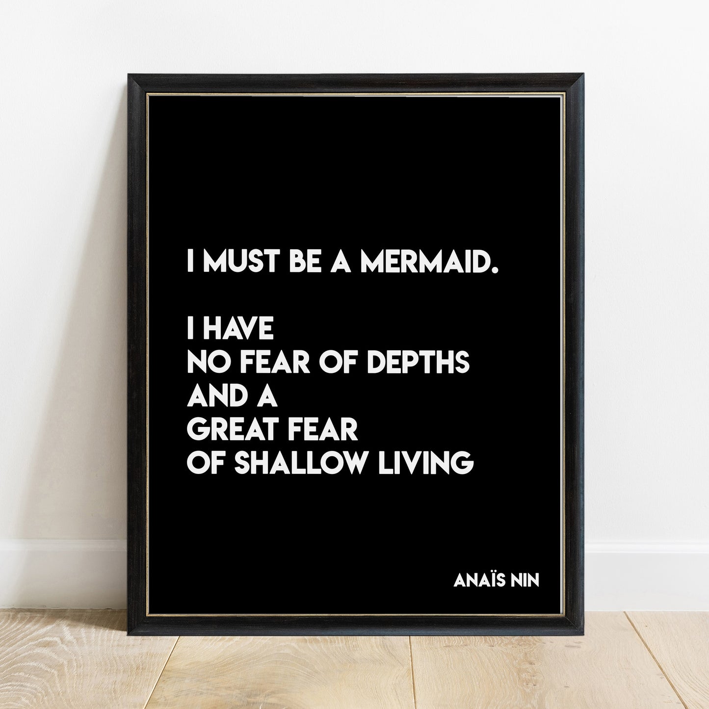 Anais Nin I must be a mermaid quote print in a black frame, black background