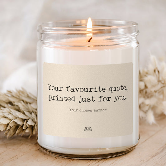 Lit soy candle in a glass jar with an example custom quote label