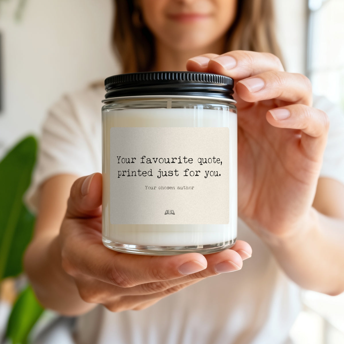 Woman holding a soy candle with an example custom quote label, showing its size