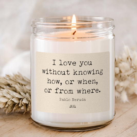 Lit soy candle in a glass jar with the Pablo Neruda I love you without knowing how label