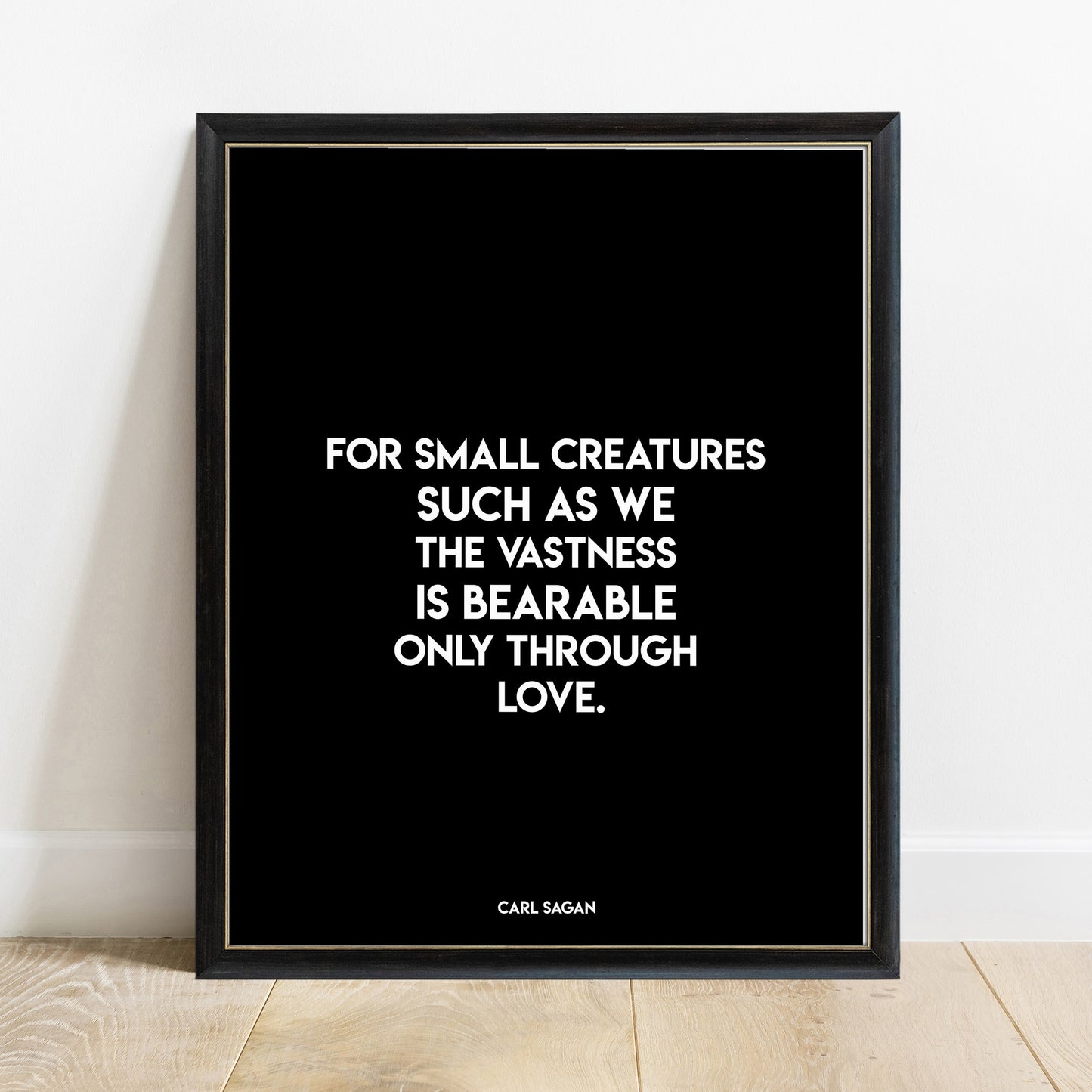 Carl Sagan vastness is bearable through love quote print in a black frame, black background