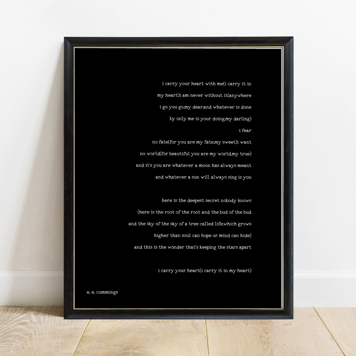 EE Cummings i carry your heart full poem print in a black frame, black background