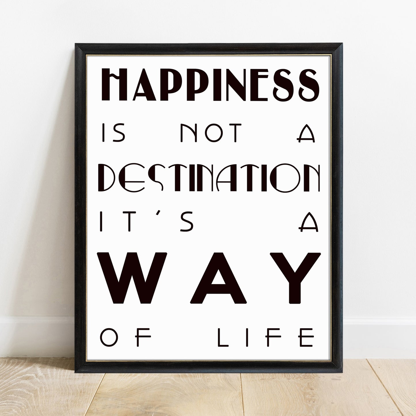 Happiness is not a destination bold quote print in a black frame, white background