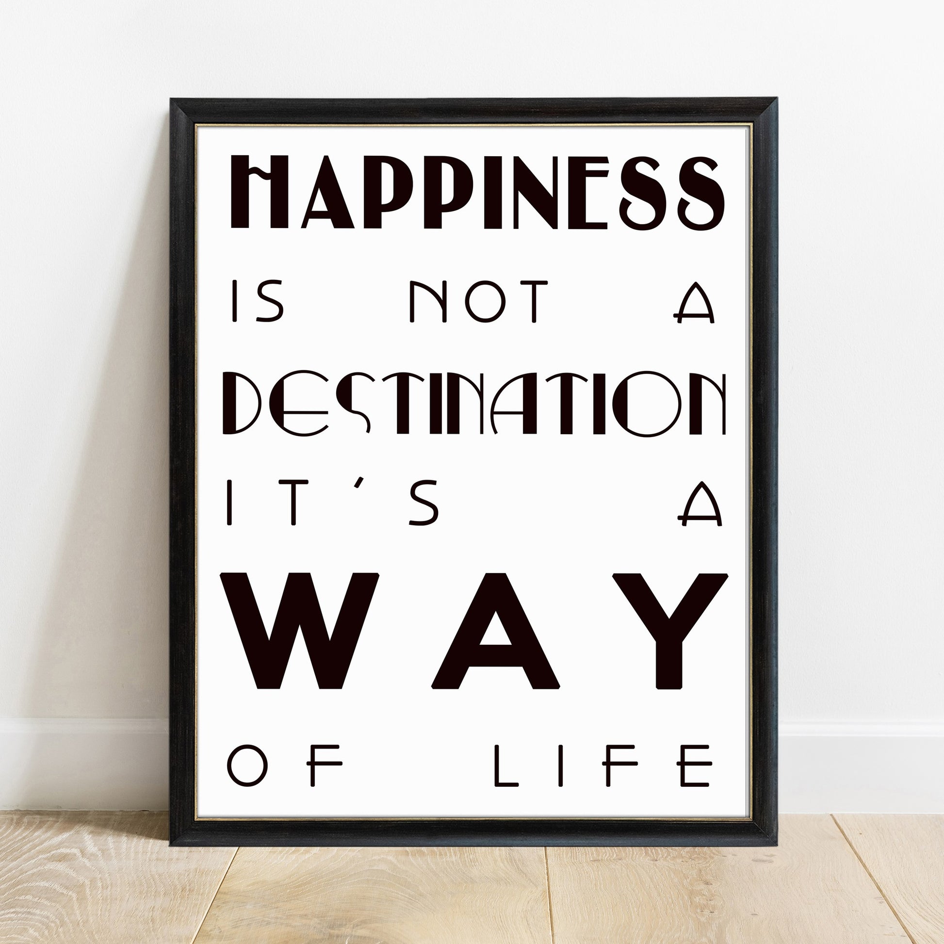 Happiness is not a destination bold quote print in a black frame, white background