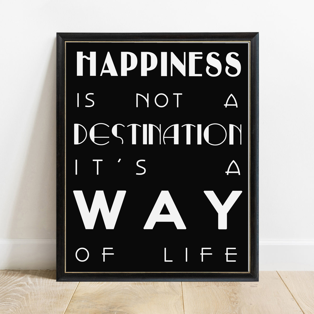 Happiness is not a destination bold quote print in a black frame, black background