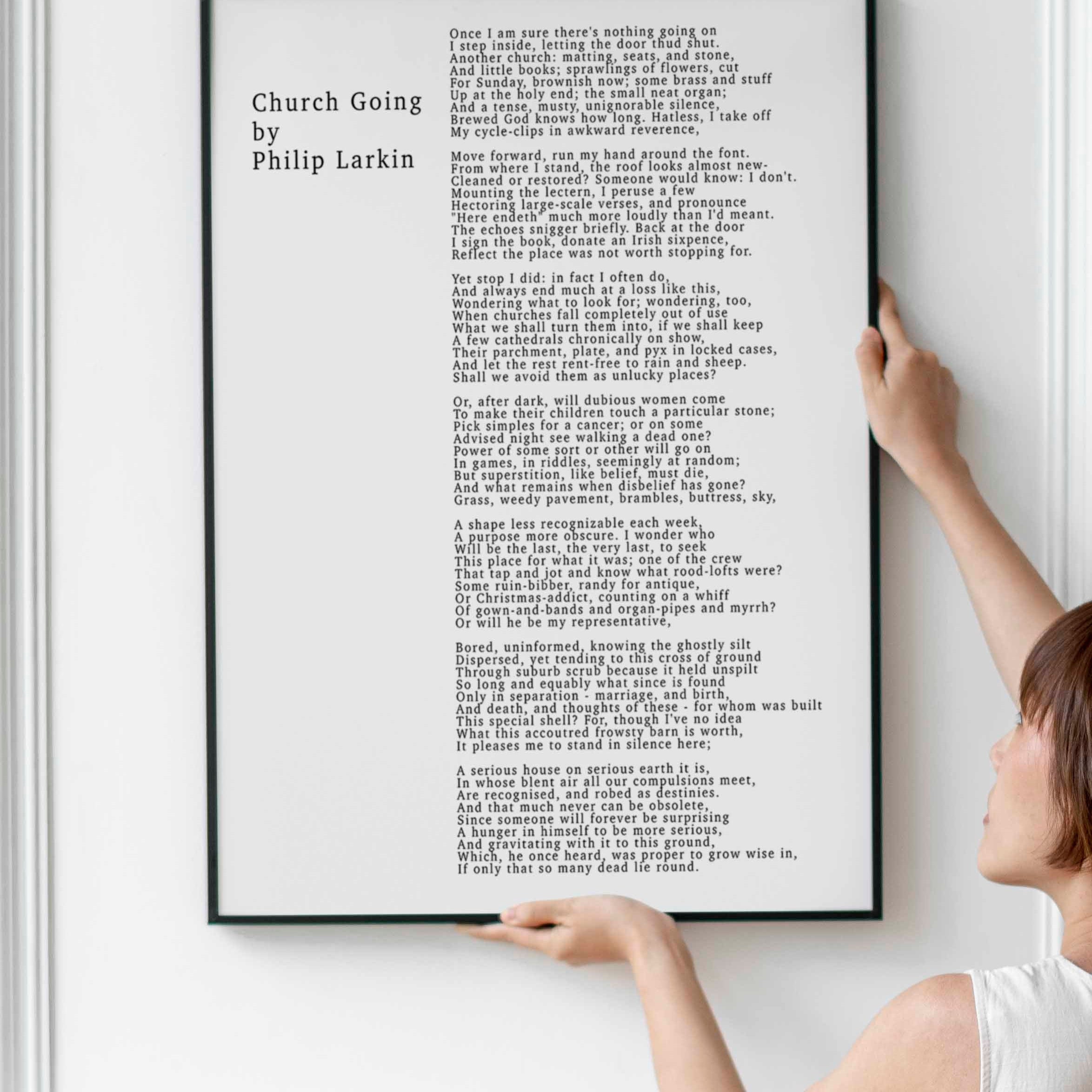 May include: A black and white framed print of a poem titled 'Church Going' by Philip Larkin. The poem is about the experience of visiting a church and the thoughts that arise from the experience. The poem is printed in a simple, sans-serif font.