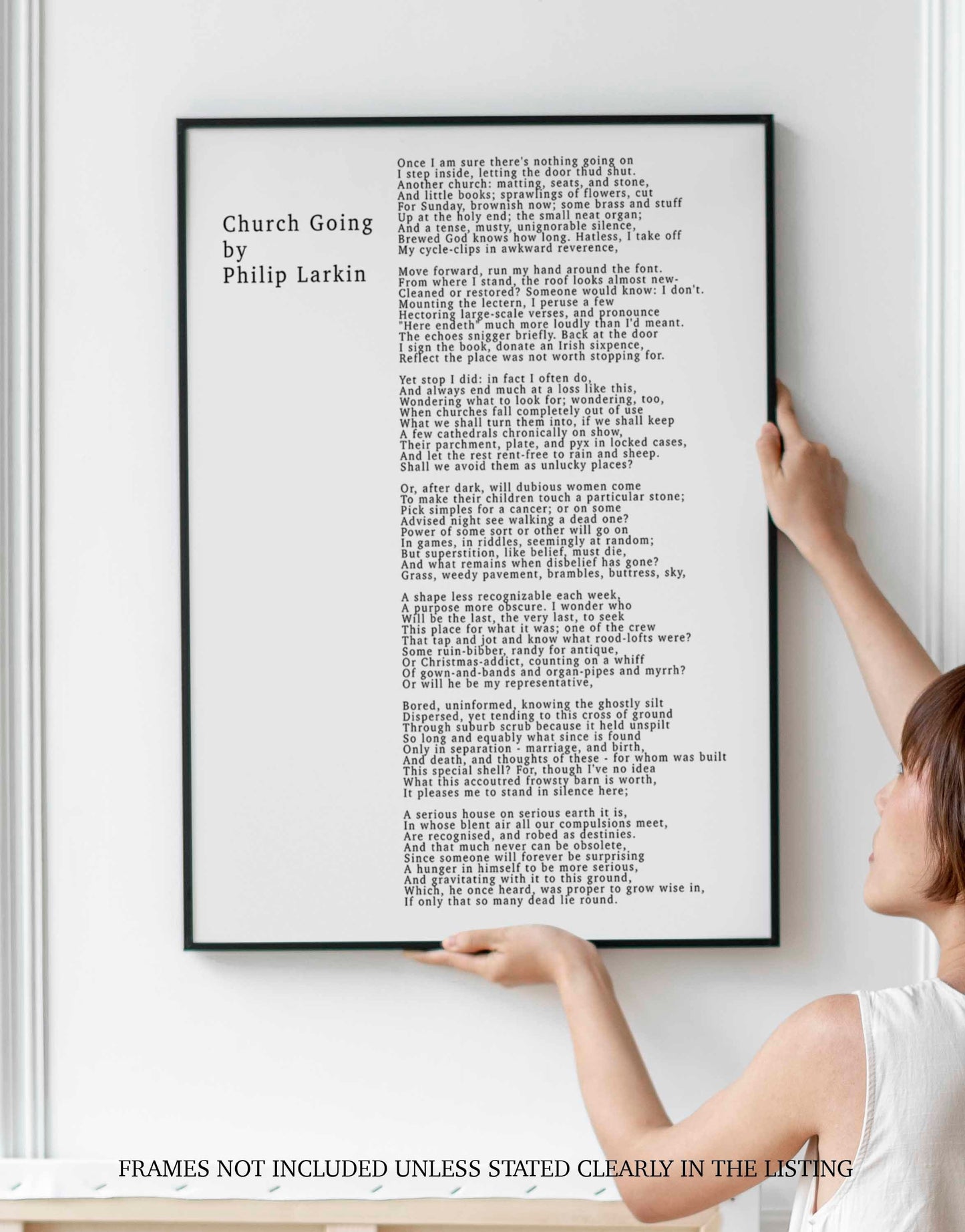 May include: A black and white framed print of a poem titled 'Church Going' by Philip Larkin. The poem is about the experience of visiting a church and the thoughts that arise from the experience. The poem is printed in a simple, sans-serif font.