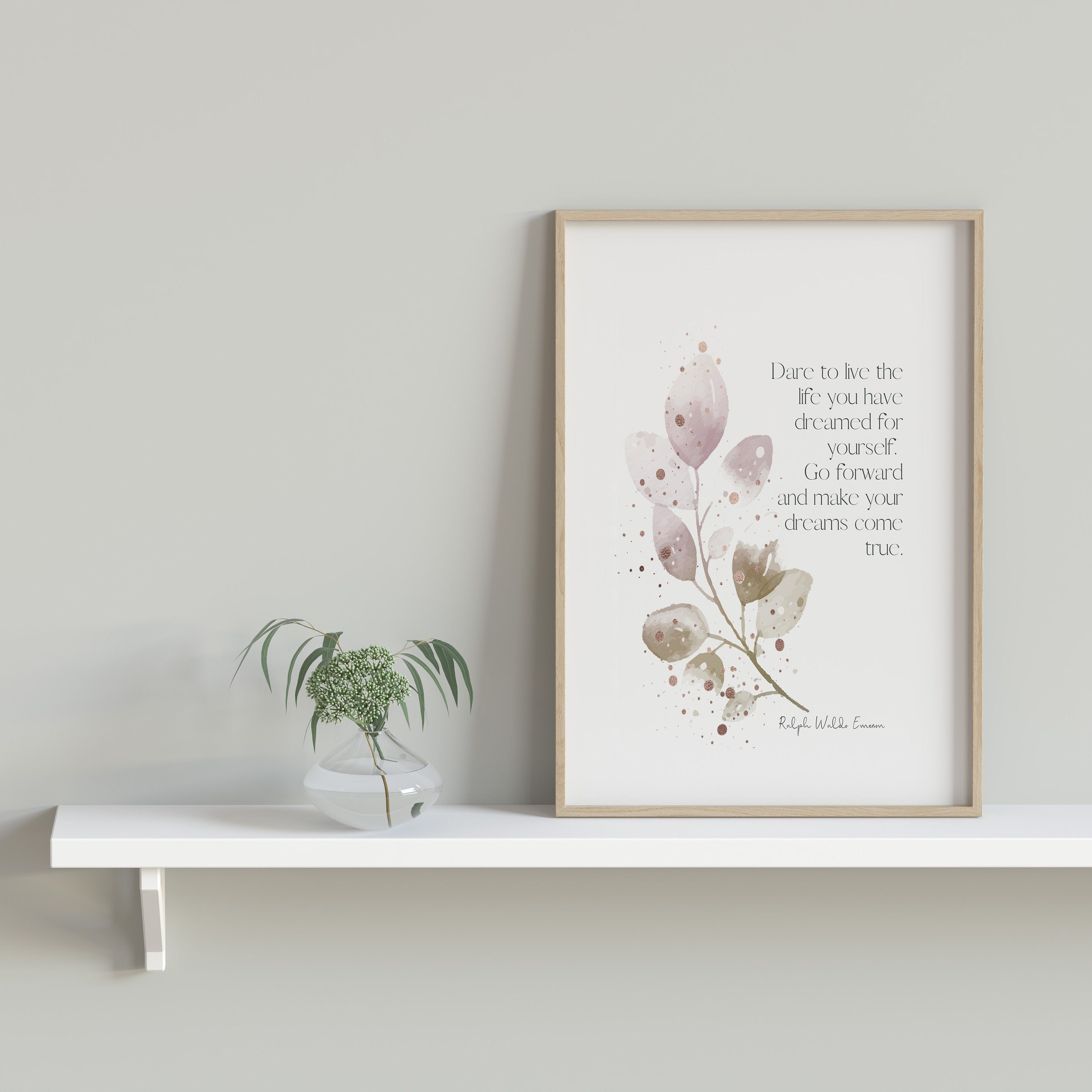 May include: A framed print with a watercolor painting of a leafy branch with pink and brown leaves. The print has a quote that reads 'Dare to live the life you have dreamed for yourself. Go forward and make your dreams come true.' The quote is attributed to Ralph Waldo Emerson.