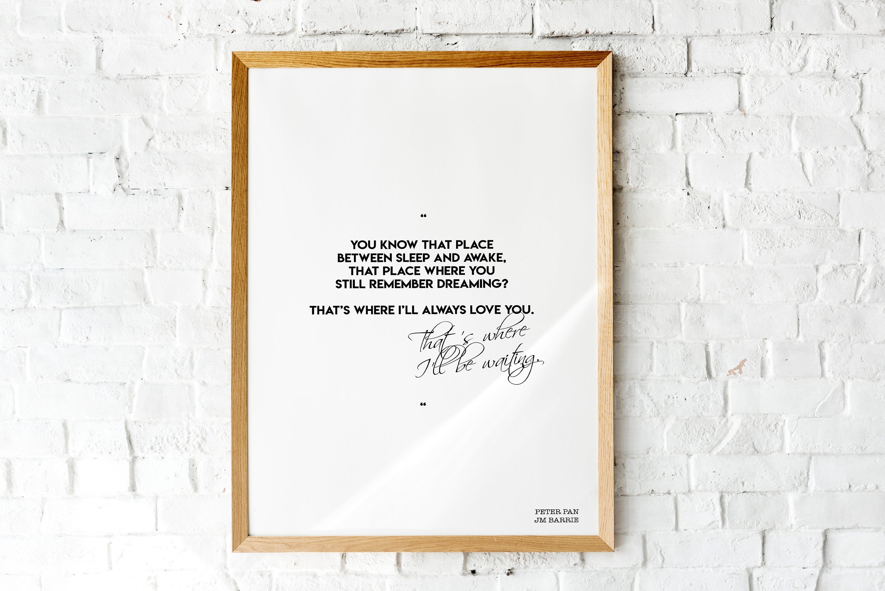 May include: A framed print with a white background and black text. The text reads: 'You know that place between sleep and awake, that place where you still remember dreaming? That's where I'll always love you. That's where I'll be waiting.' The text is in a cursive font. The bottom right corner of the print has the text 'Peter Pan JM Barrie'.