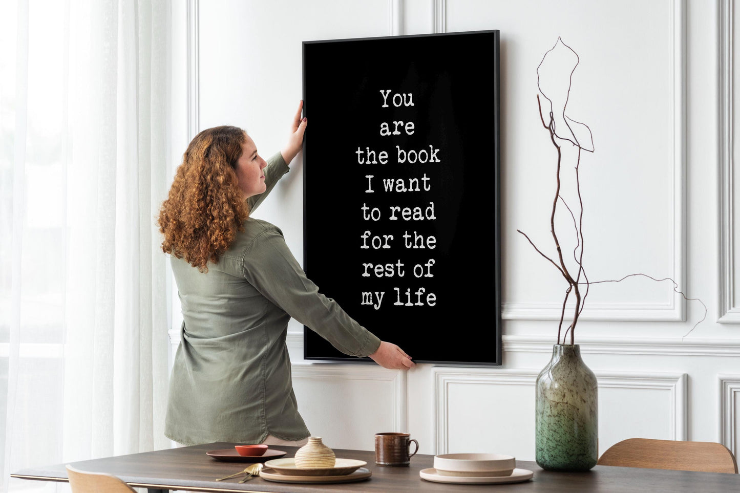 May include: A black framed print with white text that reads 'You are the book I want to read for the rest of my life'.