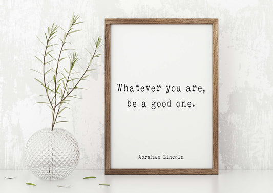 May include: A framed print with a white background and black text that reads "Whatever you are, be a good one." The text is attributed to Abraham Lincoln. The frame is brown wood.