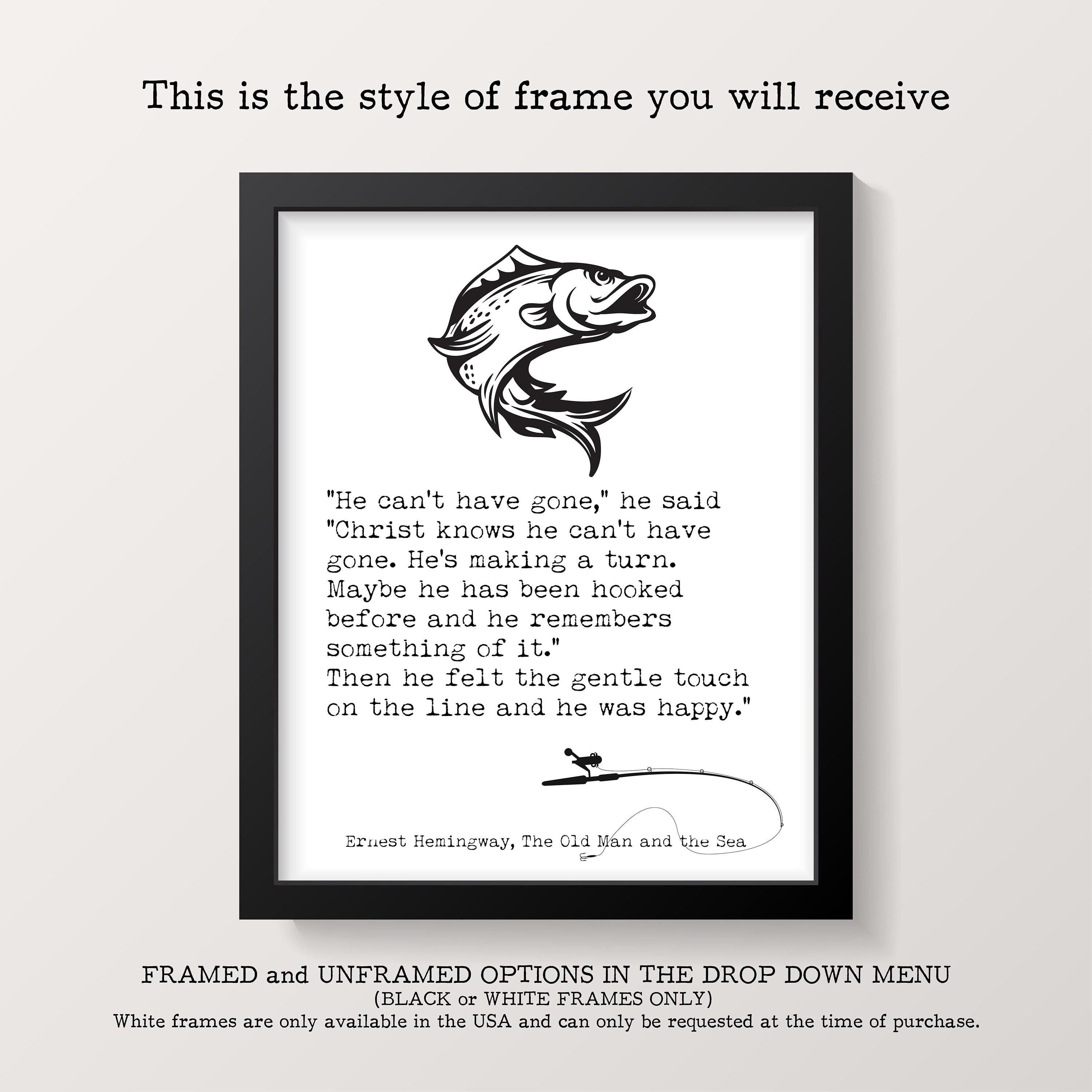 A framed print with a black border features a black-and-white illustration of a fish above a quote from Ernest Hemingway's "The Old Man and the Sea."