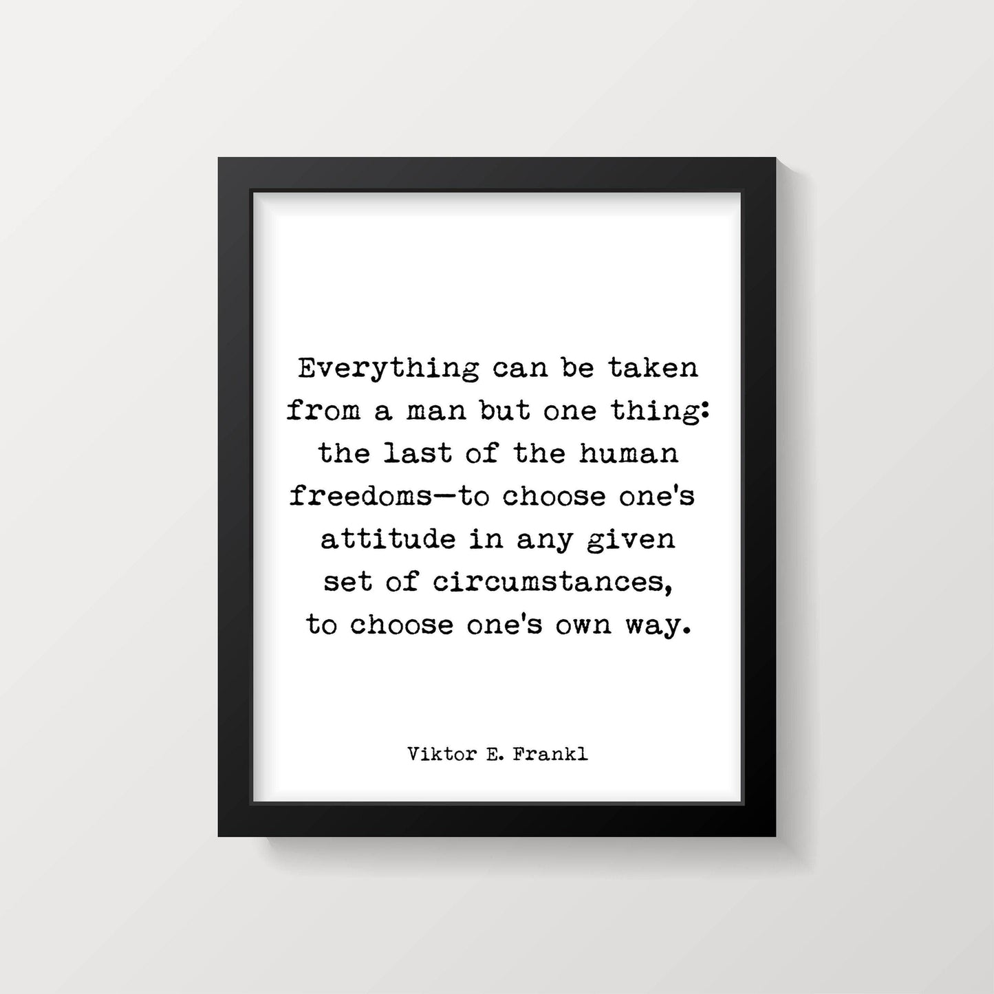 A framed white print with black text, "Everything can be taken from a man but one thing: the last of the human freedoms—to choose one's attitude in any given set of circumstances, to choose one's own way. Viktor E. Frankl," is shown on a white