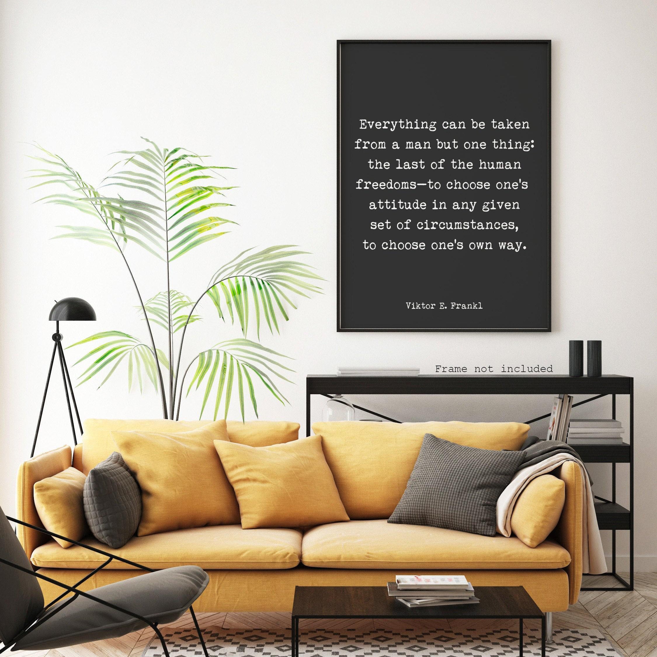 A black print with white text, "Everything can be taken from a man but one thing: the last of the human freedoms—to choose one's attitude in any given set of circumstances, to choose one's own way. Viktor E. Frankl," hangs on a white wall above a