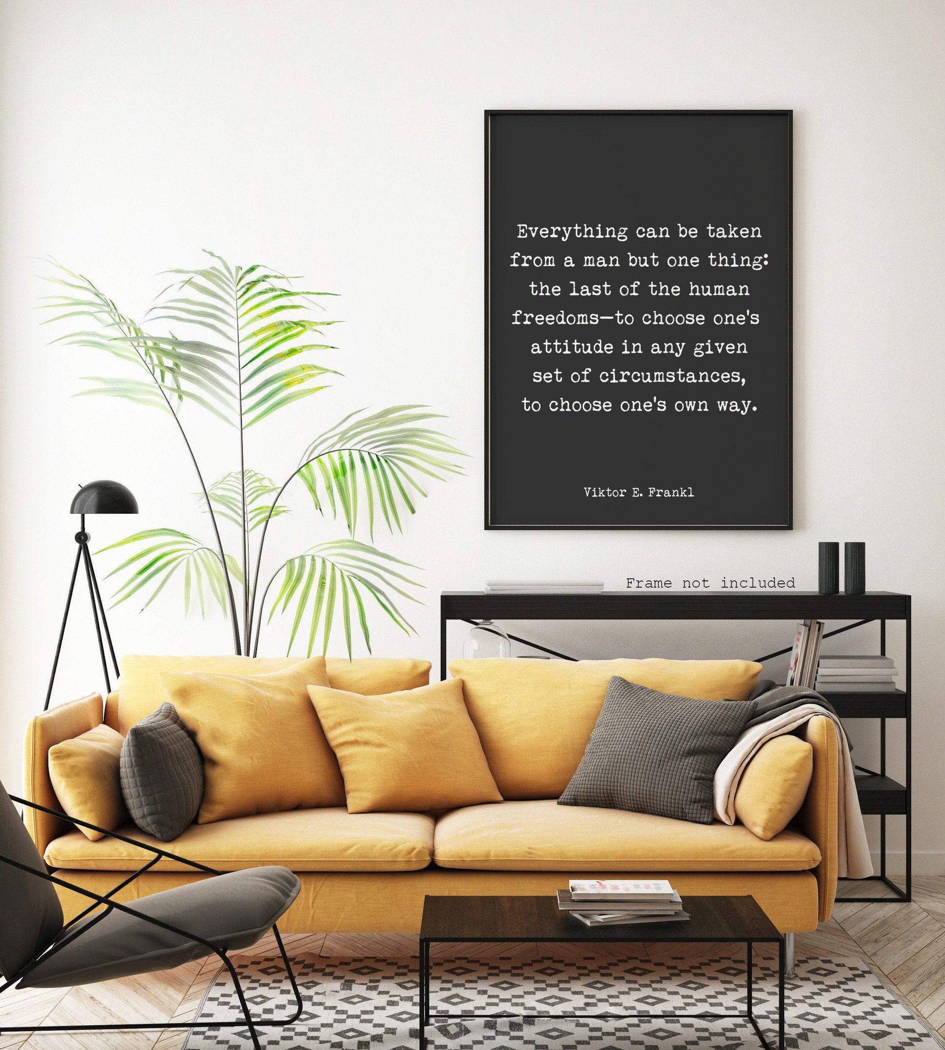 A black print with white text, "Everything can be taken from a man but one thing: the last of the human freedoms—to choose one's attitude in any given set of circumstances, to choose one's own way. Viktor E. Frankl," hangs on a white wall above a
