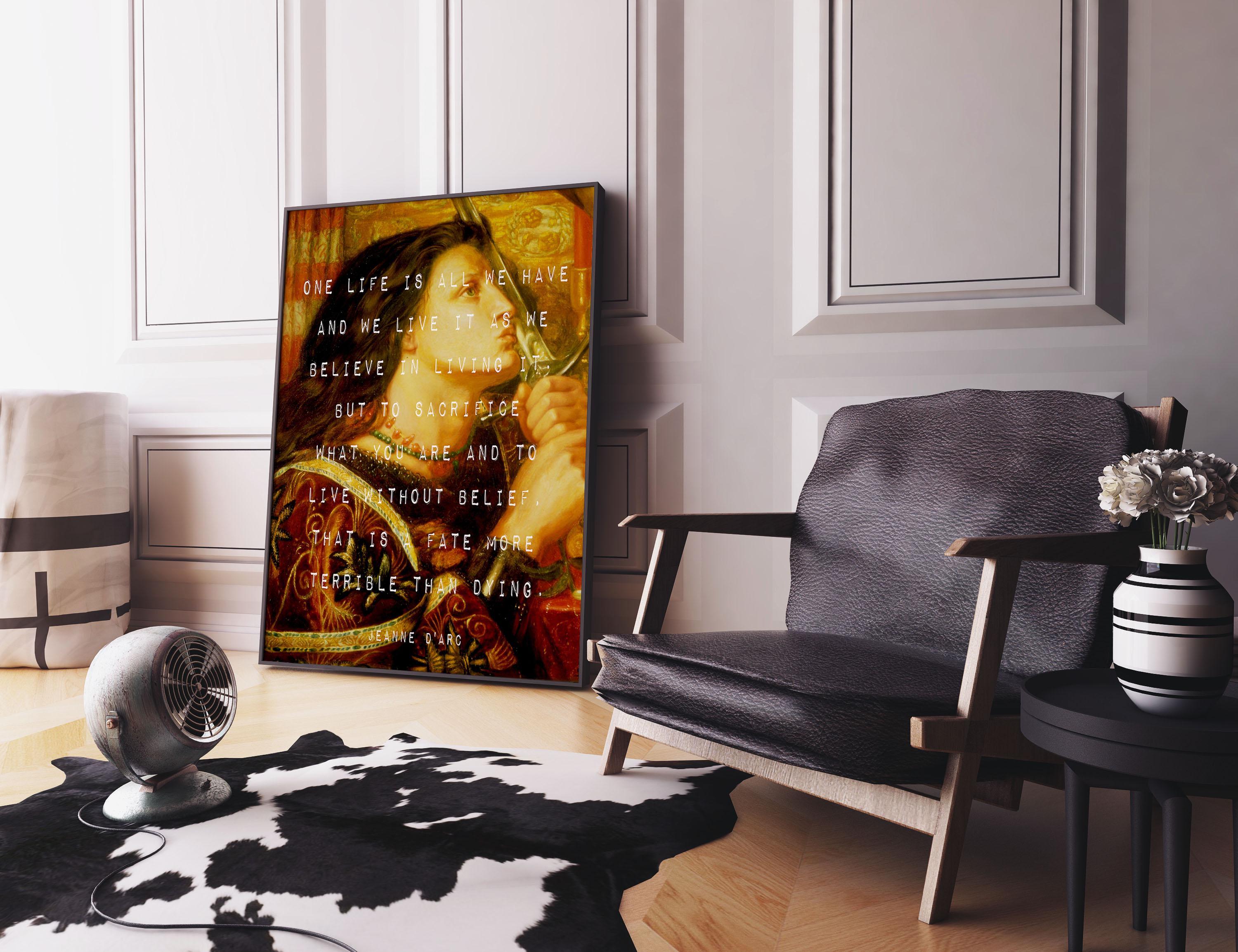 A framed print of a vintage painting with white text is propped against a white wall, next to a dark leather armchair and a small side table.
