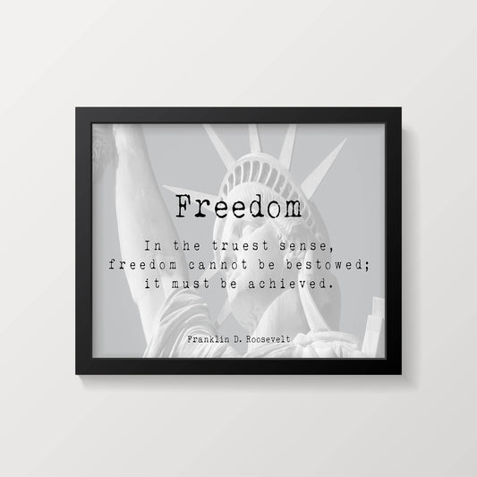 A framed print with the word "Freedom" and a quote by Franklin D. Roosevelt, overlaid on a faded image of the Statue of Liberty, against a white background.
