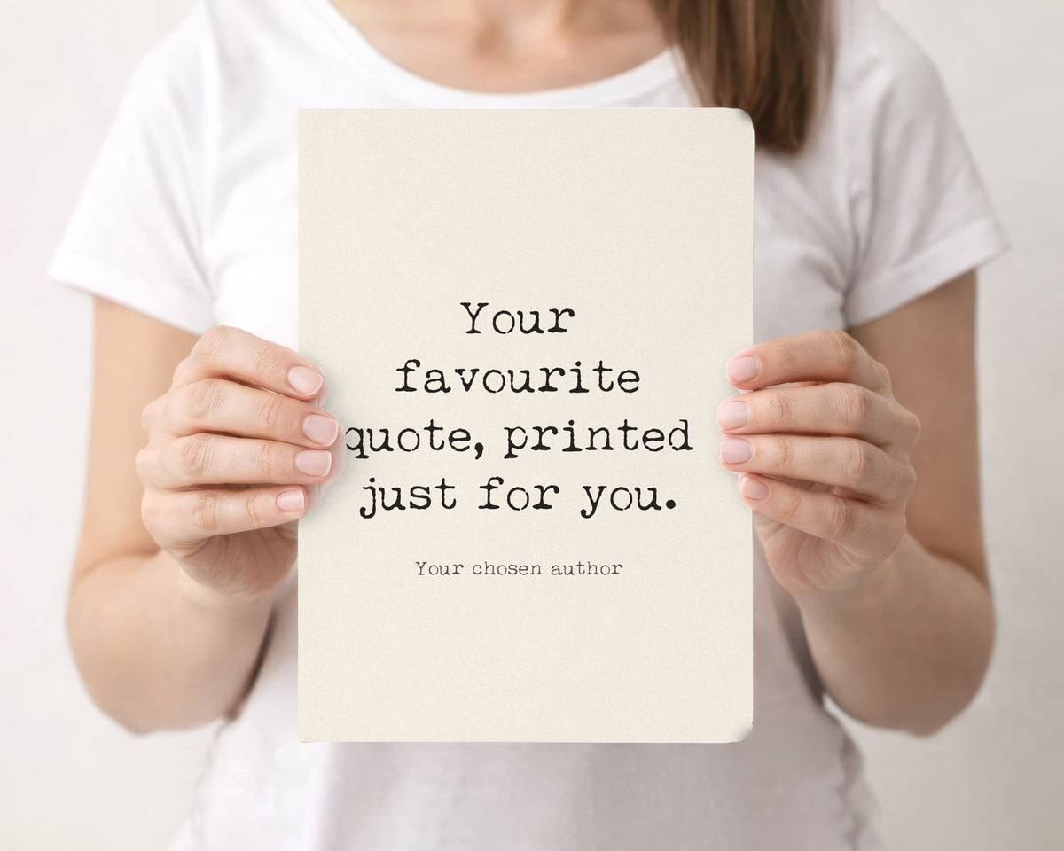 Woman holding a cream softcover journal with an example custom quote on the front