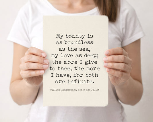 Woman holding a cream softcover journal with the Shakespeare Romeo and Juliet My bounty is as boundless as the sea quote on the front