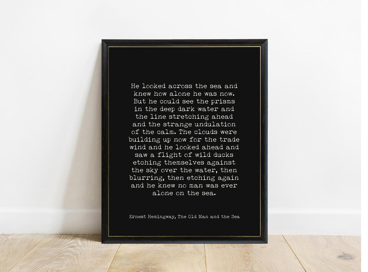 Ernest Hemingway The Old Man and the Sea no man was ever alone on the sea quote print in a black frame, black background