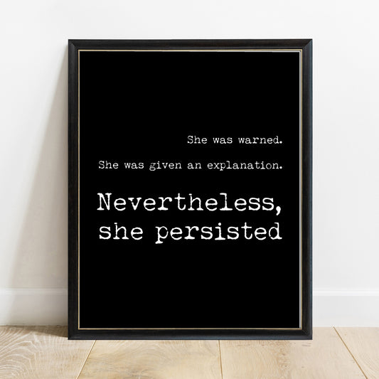 Nevertheless, she persisted feminist typewriter quote print in a black frame, black background