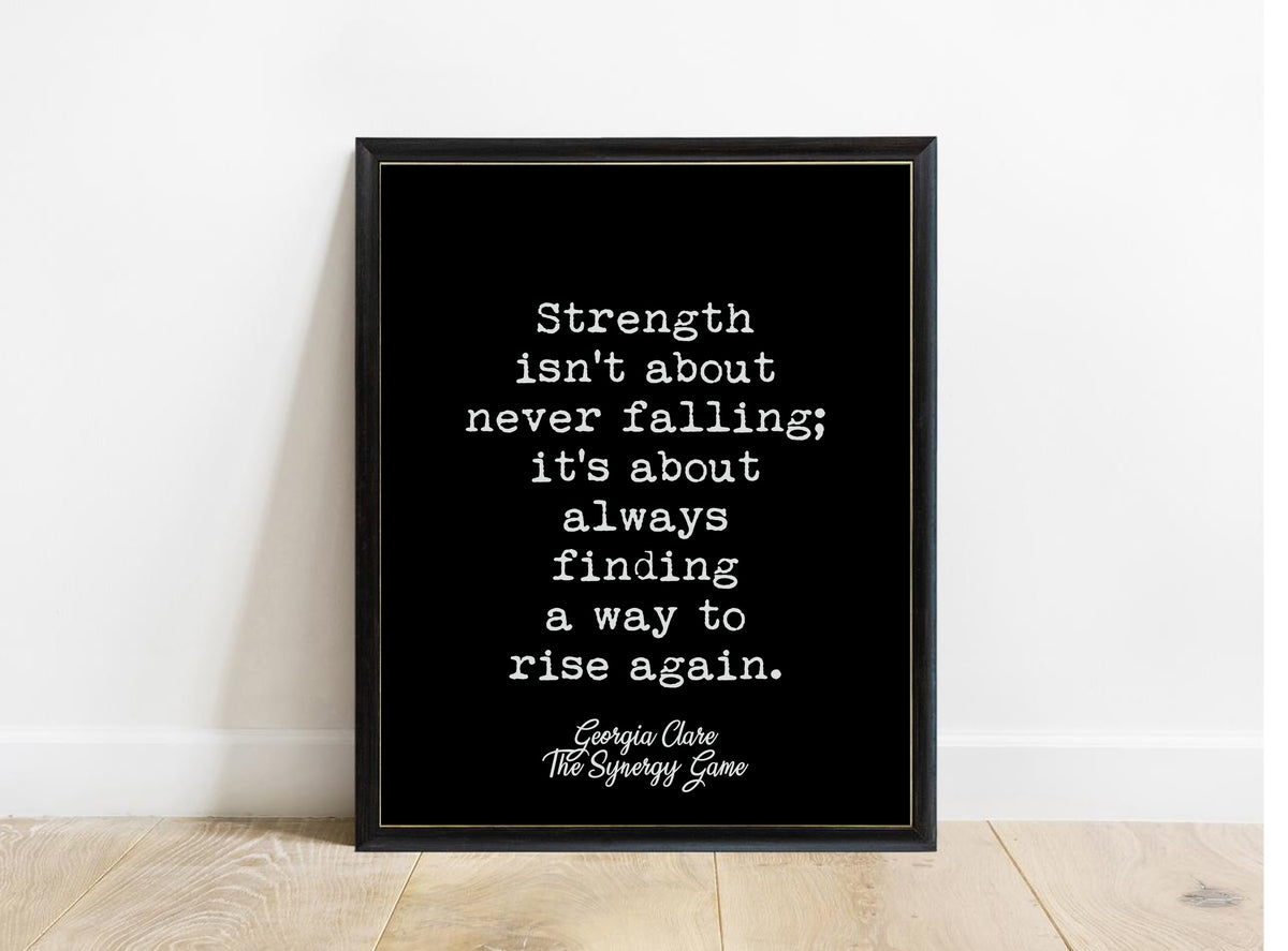 Georgia Clare Strength Isn't About Never Falling print in a black frame, black background
