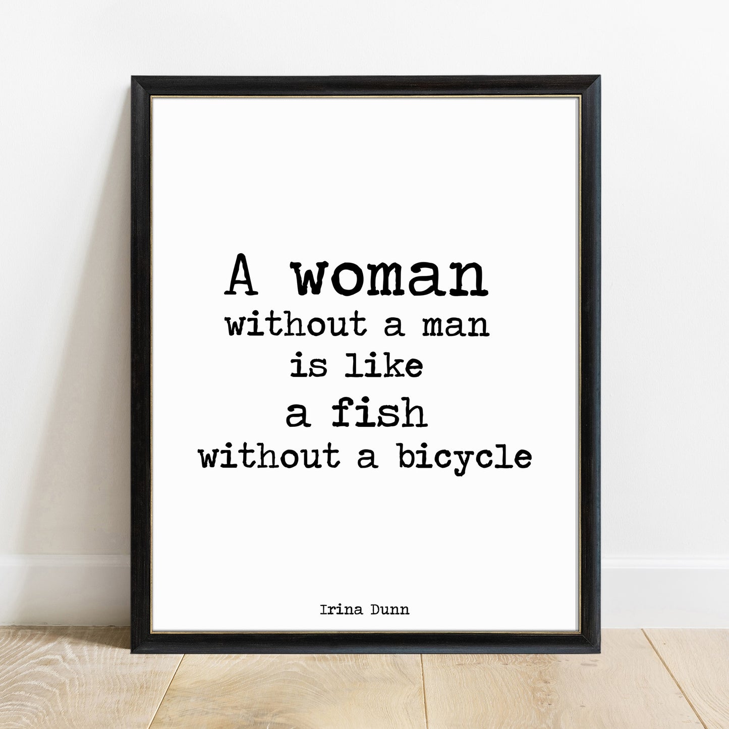 A woman without a man is like a fish without a bicycle print in a black frame, white background