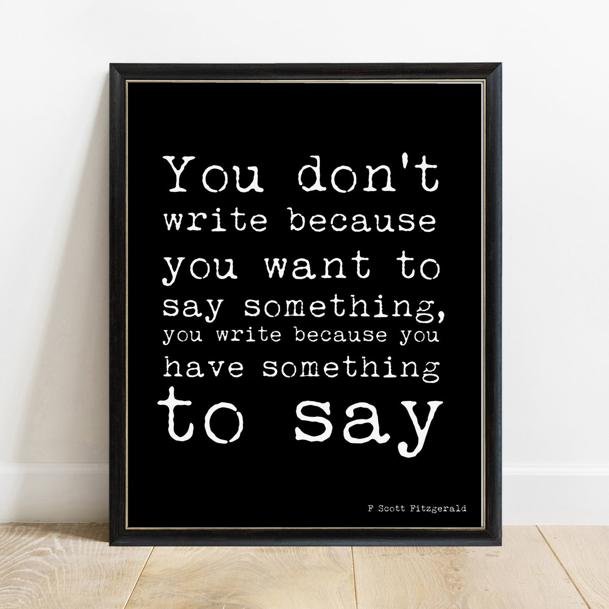 F Scott Fitzgerald you don't write because you want to say something print in a black frame, black background